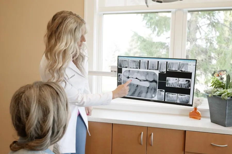 A Grandville Dental clinician reviewing treatment-planning X-rays with a seated patient
